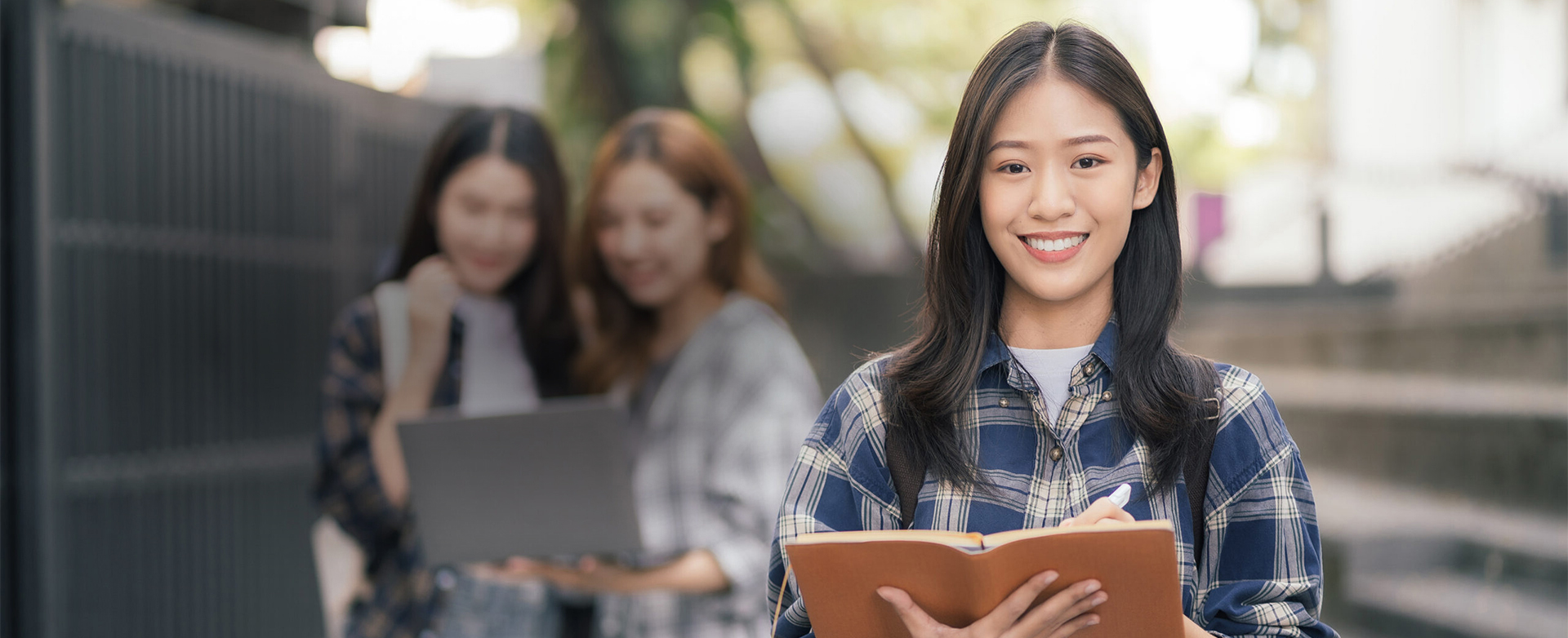 Asian college student focusing on laptop work or reading while o