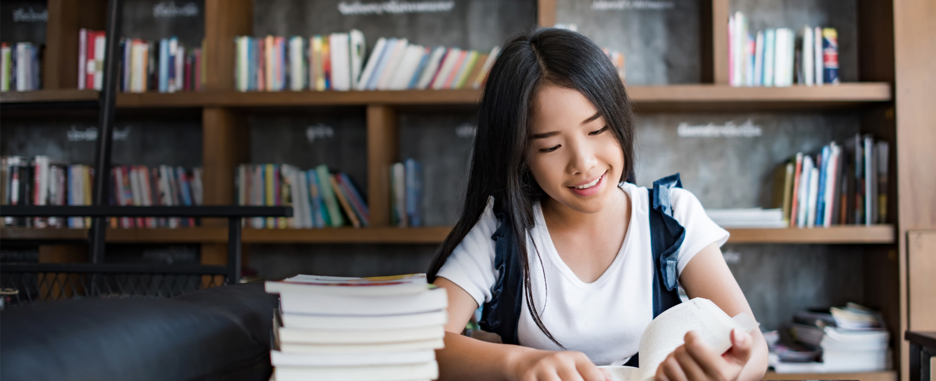 Asian college student focusing on laptop work or reading while o